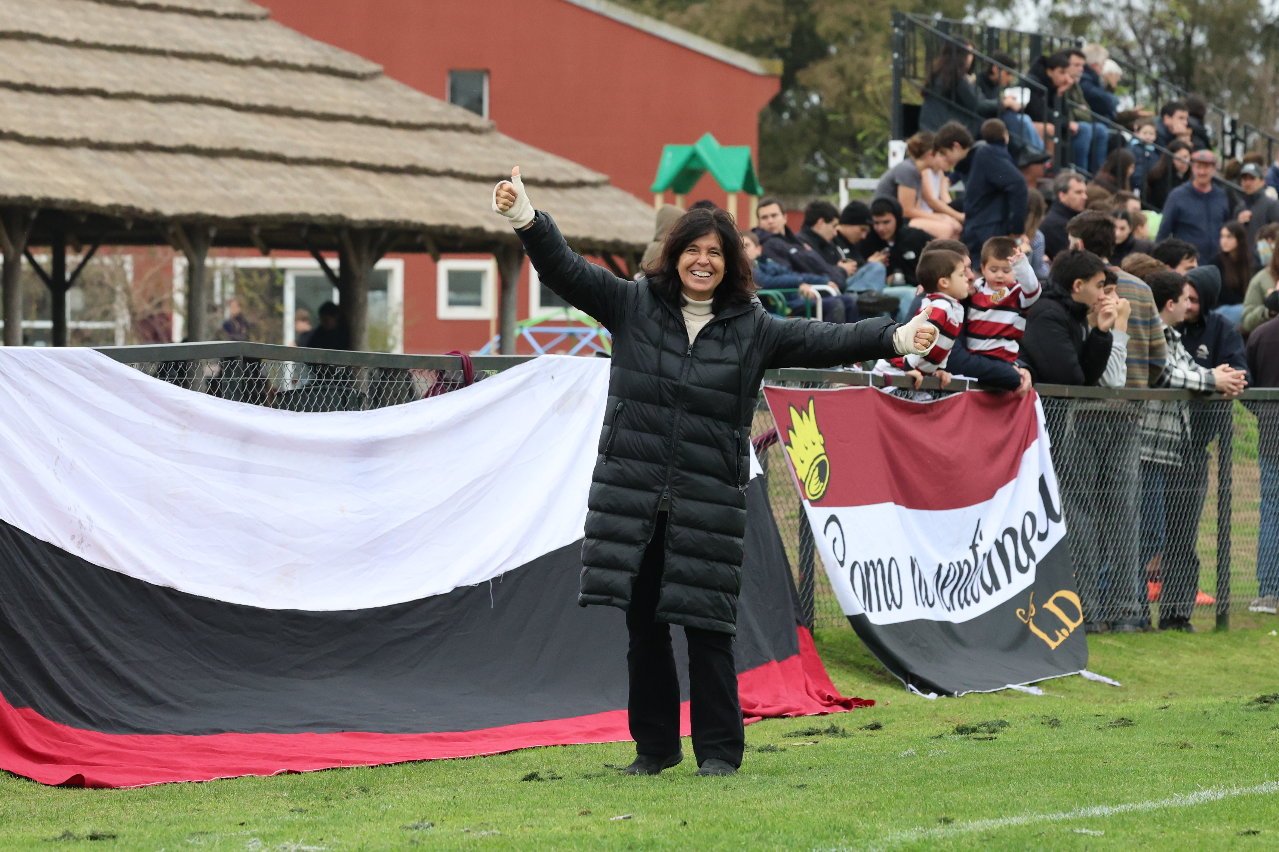 Mamá del club alentando junto a las banderas