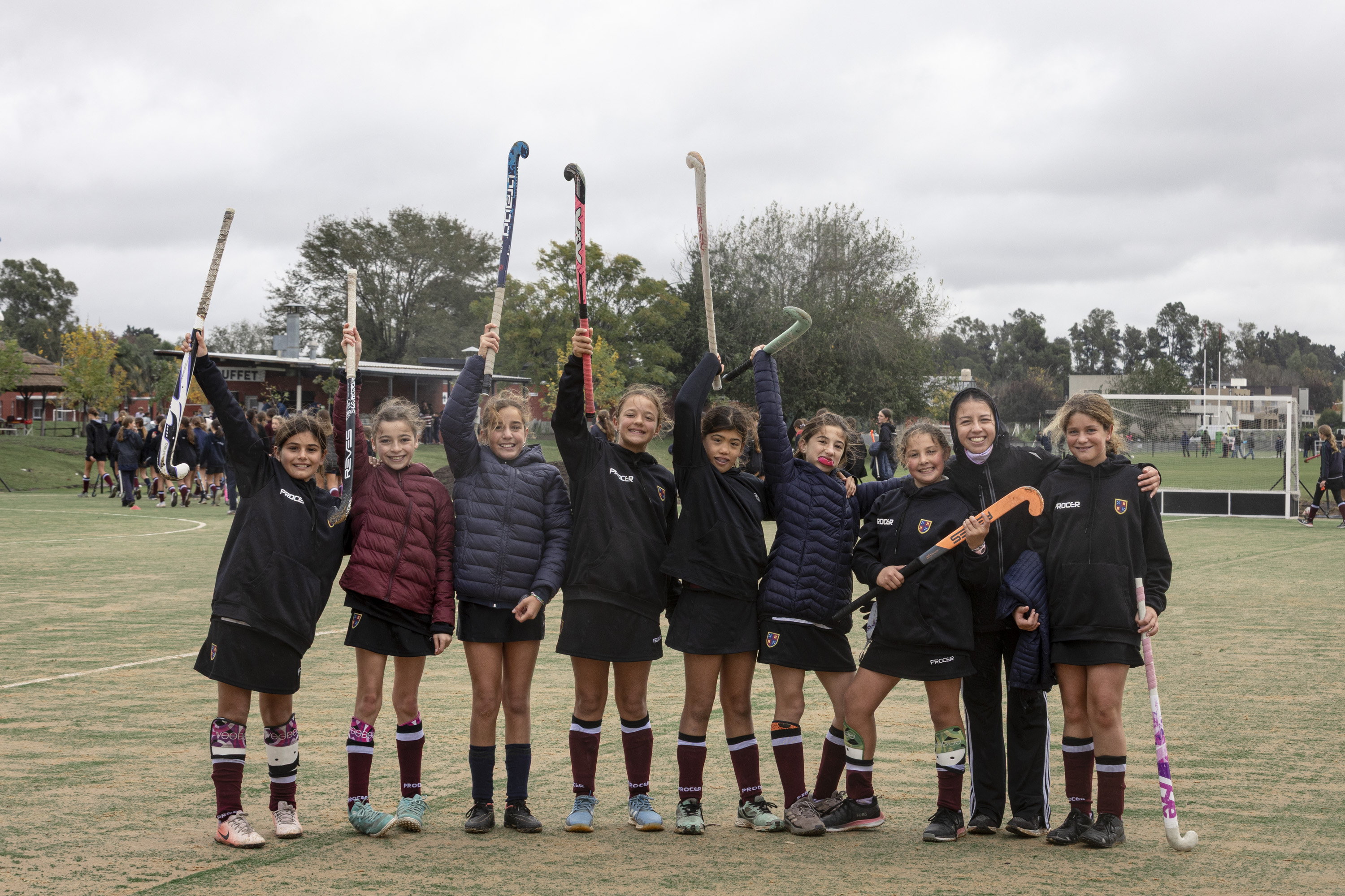 Chicas de hockey con los palos en alto